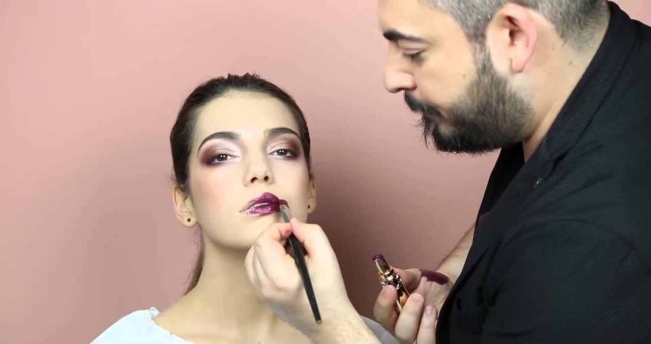 Antonio Lagani applica un rossetto prugna a una modella durante un tutorial